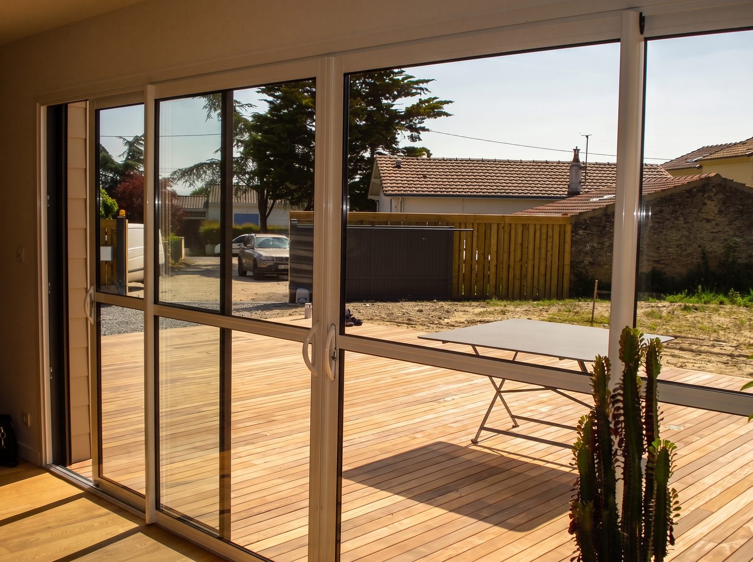Grande baie vitrée ouvrant sur la terrasse bois